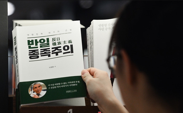 서울 시내 한 서점 베스트셀러 코너에 전시된 '반일종족주의' 책을 한 시민이 집어들고 있다. 사진=시장경제DB