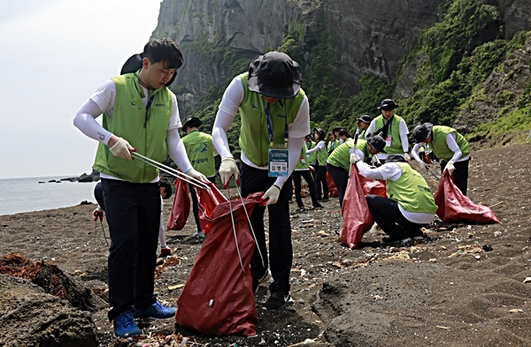 현대위아 신입사원들이 지난 15일 제주도 서귀포시 성산일출봉 앞 우뭇개해안을 청소하고 있다. 사진 제공=현대위아