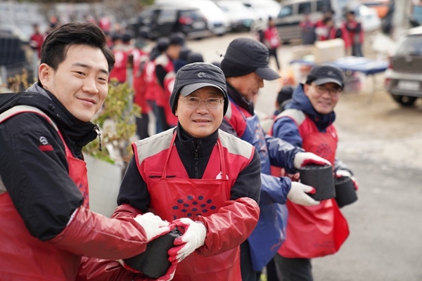 롯데건설 하석주 사장이(왼쪽에서 두 번째) 샤롯데 봉사단원들과 함께 연탄을 나르고 있다. 사진=롯데건설